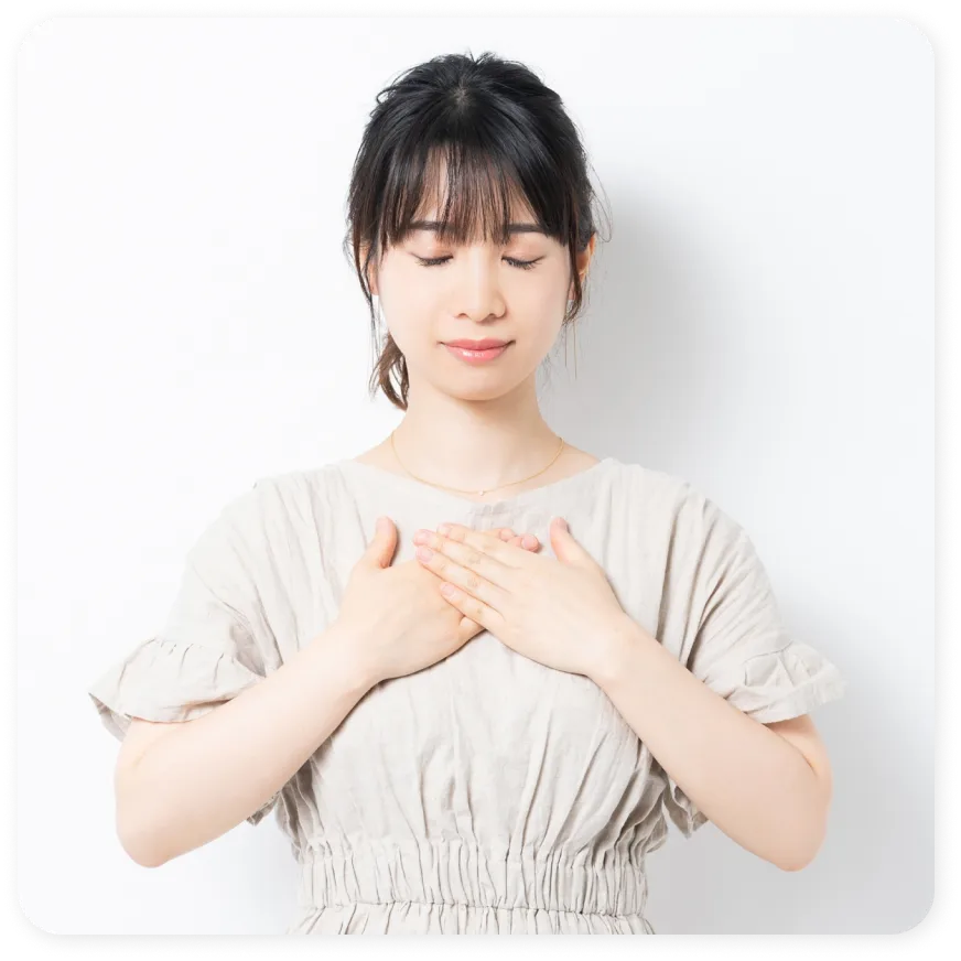 女性が目を閉じ胸に手を当てている